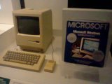 A Macintosh 128k with a...copy of Windows 1.0 next to it