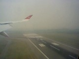 Plane shot, the runway barely visible in the smoke