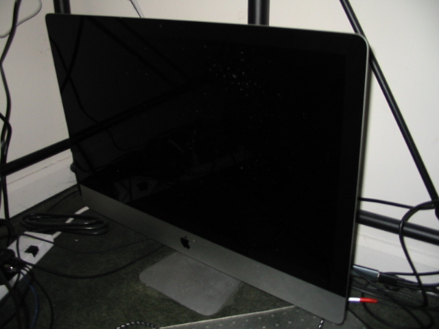 My iMac awkwardly stuffed into the corner under my desk
