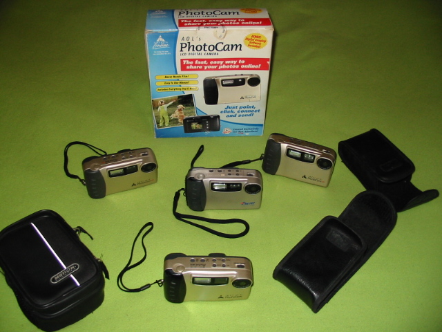 Four AOL PhotoCams, one in box, and a Pretec DC-600