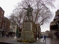 A pigeon majestically perched on the statue